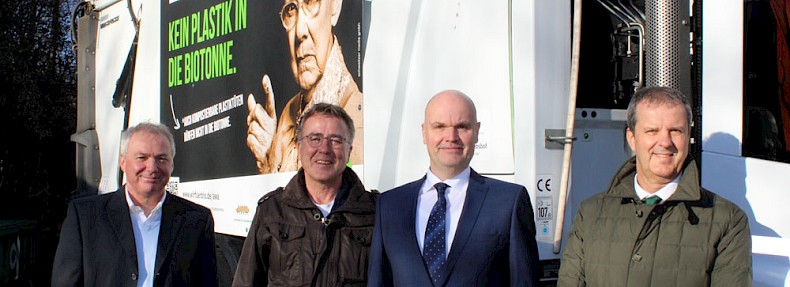 von links nach rechts: Hermann-Josef Ostlender (AWA), Siegfried Zehn (Stadt Eschweiler),  Frank Wolff (AWA) und Wilfried Kohl (ZEW) vor einem Müllfahrzeug mit dem Kampagnenmotiv
